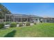 View of the property's backyard featuring a screened in patio and well manicured landscaping at 5554 Eastwind Dr, Sarasota, FL 34233