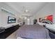 Spacious bedroom featuring a large bed, ceiling fan, and a mounted TV for comfortable relaxation at 5554 Eastwind Dr, Sarasota, FL 34233