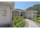 Inviting home entrance with a paved walkway, manicured shrubs, and gray facade at 5554 Eastwind Dr, Sarasota, FL 34233