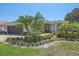 Charming home with lush landscaping, palm trees, and a tile roof on a sunny day at 5554 Eastwind Dr, Sarasota, FL 34233