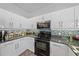 Modern kitchen featuring white cabinets, granite countertops, and stainless steel appliances at 5554 Eastwind Dr, Sarasota, FL 34233