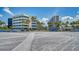 Expansive beach view with palm trees and condo buildings in the background on a clear day at 5920 Midnight Pass Rd # 406, Sarasota, FL 34242