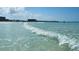 Beach view features pristine turquoise waters and a sprawling shoreline with nearby buildings at 5920 Midnight Pass Rd # 406, Sarasota, FL 34242