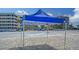 Spacious beach with a blue tent and condo buildings in the background on a clear day at 5920 Midnight Pass Rd # 406, Sarasota, FL 34242