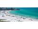 Elevated beach view with turquoise ocean waters, beach umbrellas, white sands, and many people enjoying the shore at 5920 Midnight Pass Rd # 406, Sarasota, FL 34242