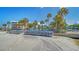 Beautiful beach view with stacked blue beach chairs, palm trees and condo buildings in the background on a clear day at 5920 Midnight Pass Rd # 406, Sarasota, FL 34242