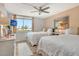 Bright bedroom featuring two beds, a ceiling fan, and a large window with scenic views at 5920 Midnight Pass Rd # 406, Sarasota, FL 34242