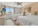 Bright bedroom featuring two beds, a ceiling fan, and a large window with scenic views at 5920 Midnight Pass Rd # 406, Sarasota, FL 34242