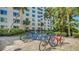 Outdoor bike rack with several bicycles and a condo building in the background at 5920 Midnight Pass Rd # 406, Sarasota, FL 34242