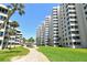 Lush green lawn and well-maintained path leading to multi-story condominium building at 5920 Midnight Pass Rd # 406, Sarasota, FL 34242