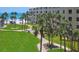 Lovely view of lush green lawn with palm trees leading to a beach and coastal condos at 5920 Midnight Pass Rd # 406, Sarasota, FL 34242