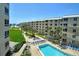 Scenic view of a community featuring a pool, palm trees, and well-maintained buildings near the beach at 5920 Midnight Pass Rd # 406, Sarasota, FL 34242