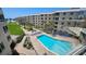Beautiful exterior view showcasing a community pool, lush landscaping, and beachfront access at 5920 Midnight Pass Rd # 406, Sarasota, FL 34242