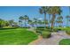 Lush manicured grounds with tropical palm trees and paver walkway leading to the beach at 5920 Midnight Pass Rd # 406, Sarasota, FL 34242