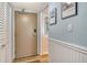 Welcoming hallway with wood-look flooring, white wainscoting, and beachy decor at 5920 Midnight Pass Rd # 406, Sarasota, FL 34242