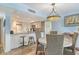 Bright kitchen and dining area with counter seating and decorative lighting fixture at 5920 Midnight Pass Rd # 406, Sarasota, FL 34242