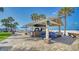 Outdoor grill area with stone surround, stainless steel grills, and picnic tables at 5920 Midnight Pass Rd # 406, Sarasota, FL 34242