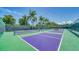 Outdoor community pickleball courts are surrounded by palm trees and a fence at 5920 Midnight Pass Rd # 406, Sarasota, FL 34242