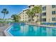 Community pool with inviting turquoise water, surrounded by lounge chairs and palm trees at 5920 Midnight Pass Rd # 406, Sarasota, FL 34242