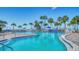 Community pool featuring lounge chairs, umbrellas and palm trees at 5920 Midnight Pass Rd # 406, Sarasota, FL 34242