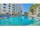 A sparkling swimming pool is surrounded by tall palm trees and an apartment building at 5920 Midnight Pass Rd # 406, Sarasota, FL 34242