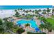 Inviting kidney-shaped pool surrounded by palm trees and lounge chairs near the beach at 5920 Midnight Pass Rd # 406, Sarasota, FL 34242