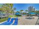 Inviting pool area with blue lounge chairs, tables and palm trees on a clear day at 5920 Midnight Pass Rd # 406, Sarasota, FL 34242