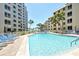 Community pool with inviting turquoise water, surrounded by lounge chairs and palm trees at 5920 Midnight Pass Rd # 406, Sarasota, FL 34242