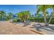 Landscaped tennis area featuring palm trees, foliage, and shade canopies at 5920 Midnight Pass Rd # 406, Sarasota, FL 34242