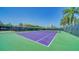 Spacious tennis court with palm trees on a sunny day, with visible residences at 5920 Midnight Pass Rd # 406, Sarasota, FL 34242