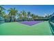 Well-maintained tennis court, surrounded by tall palm trees on a clear day at 5920 Midnight Pass Rd # 406, Sarasota, FL 34242