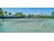 Expansive tennis court area with palm trees and shade structures on a sunny day at 5920 Midnight Pass Rd # 406, Sarasota, FL 34242