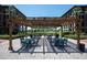 Outdoor dining area in the courtyard with multiple tables and chairs under a wooden pergola at 6100 Gulfport S Blvd # 117, Gulfport, FL 33707