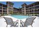 Condo community pool view from lounge chairs; pool is surrounded by lush tropical foliage at 6100 Gulfport S Blvd # 117, Gulfport, FL 33707