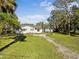 Exterior of the house surrounded by lush greenery and mature trees at 611 29Th E St, Bradenton, FL 34208