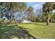Exterior view of the home surrounded by a large grassy yard and trees at 611 29Th E St, Bradenton, FL 34208