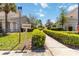 Inviting clubhouse entrance featuring a well-maintained walkway lined with lush hedges and mature trees at 6339 Bay Cedar Ln # 102, Bradenton, FL 34203