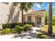 Inviting entryway featuring a tiled roof, arched doorway, and tropical landscaping at 6339 Bay Cedar Ln # 102, Bradenton, FL 34203