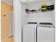 Neat laundry room equipped with modern washer and dryer units, plus storage shelf at 6339 Bay Cedar Ln # 102, Bradenton, FL 34203