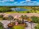 Aerial view showcases the golf course, lake with fountain and beautiful community clubhouse at 6524 Willowshire Way, Bradenton, FL 34212