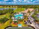 Aerial view of golf course, pool, clubhouse, palm trees, and well-manicured grounds at 6524 Willowshire Way, Bradenton, FL 34212