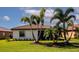Lush backyard with well-manicured lawn and mature palm trees for a private retreat at 6524 Willowshire Way, Bradenton, FL 34212