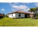 Home's backyard offers a manicured lawn, tropical trees, and a serene spot for relaxation at 6524 Willowshire Way, Bradenton, FL 34212