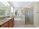 Elegant bathroom with granite counters, soaking tub, and glass-enclosed shower at 6524 Willowshire Way, Bradenton, FL 34212