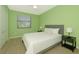 Cozy bedroom featuring a large bed, light green walls, and a window for natural light at 6524 Willowshire Way, Bradenton, FL 34212