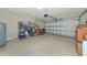 Spacious two car garage with white epoxy floors provides ample storage with shelving and a garage door opener at 6524 Willowshire Way, Bradenton, FL 34212
