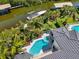 An aerial view features a pristine pool and a dock for boats, set in a backdrop of lush greenery at 7118 Hawks Harbor Cir, Bradenton, FL 34207
