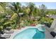 Resort style pool with loungers, hot tub, and landscaping with mature tropical foliage in the backyard at 7118 Hawks Harbor Cir, Bradenton, FL 34207