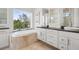 Luxurious primary bathroom featuring double sinks, a soaking tub, and natural light at 7118 Hawks Harbor Cir, Bradenton, FL 34207
