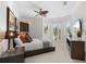 Comfortable bedroom with a ceiling fan, built-in shelving, and access to a private balcony at 7118 Hawks Harbor Cir, Bradenton, FL 34207